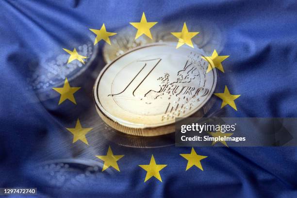 european union flag and eurocoins. one euro coin in he middle of the flag. - european union symbol stock-fotos und bilder