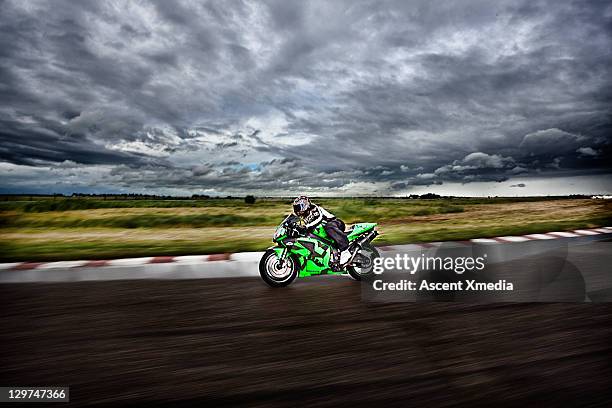 motorcyclist races around wet track on stormy day - moto 個照片及圖片檔