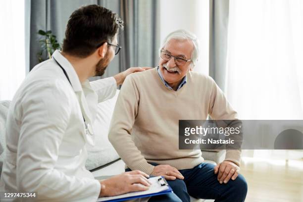 giovane medico in una chiamata a casa - uomo anziano felice foto e immagini stock