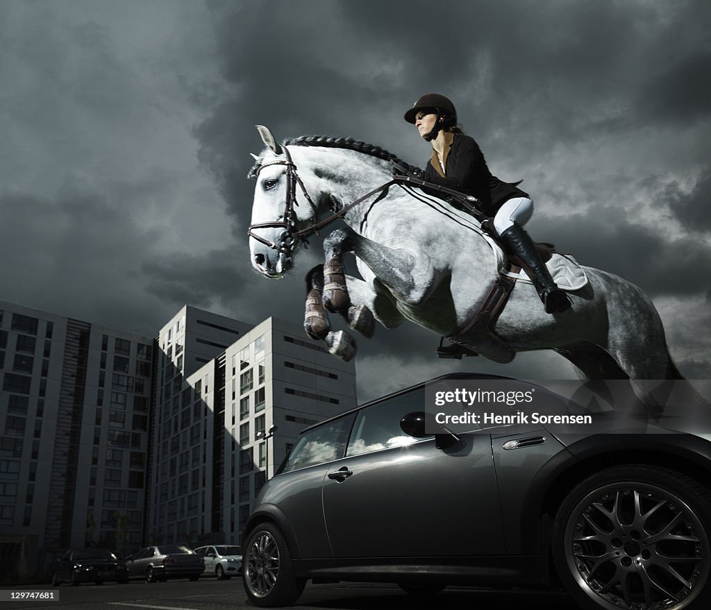 Horse and rider jumping in urban surroundings