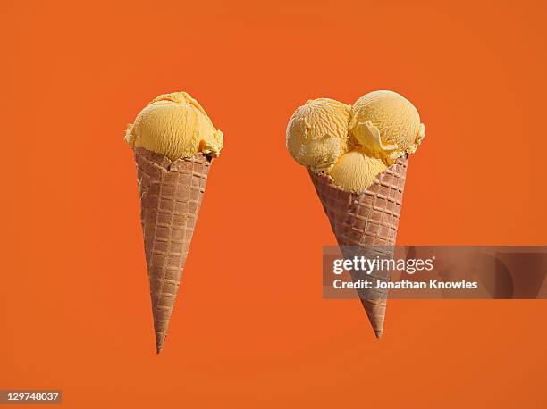 two ice creams, with one and three scoops - compare size stockfoto's en -beelden