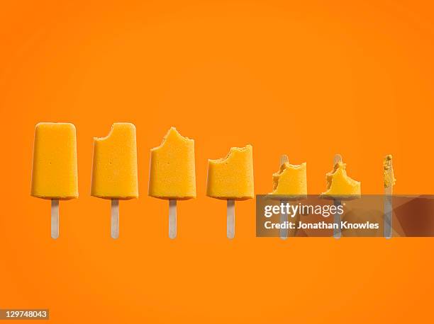 row of ice cream lollies eaten at different stages - かじりかけ ストックフォトと画像