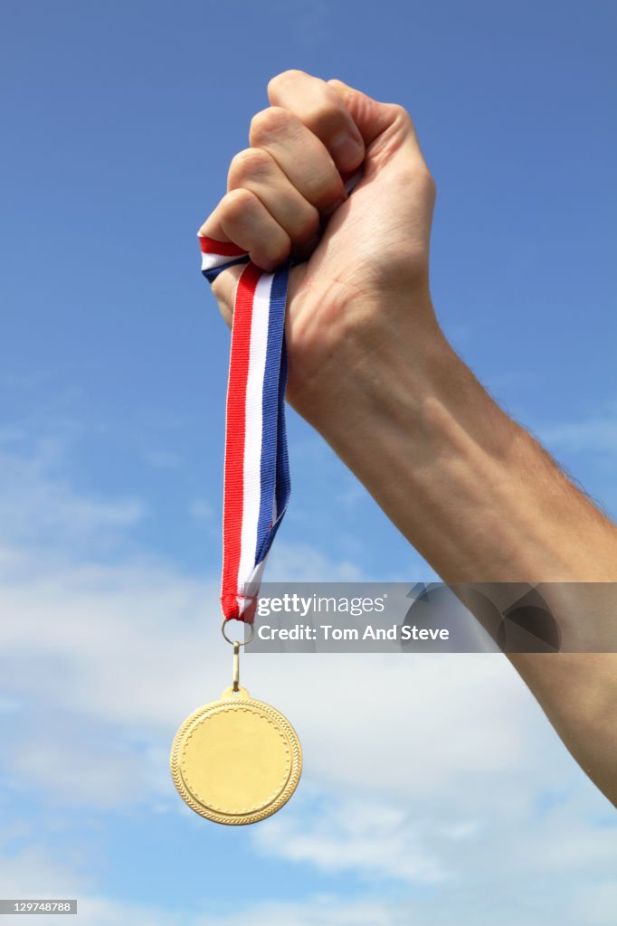 . Athlete holding Gold Medal to the sky