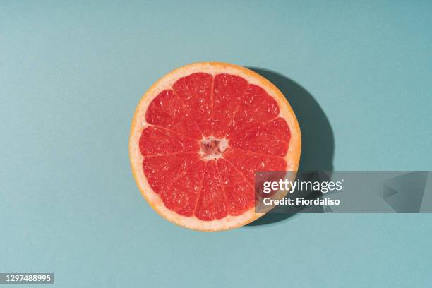 creative pattern made with fresh slices of grapefruit on vibrant blue background - grapefruit bildbanksfoton och bilder