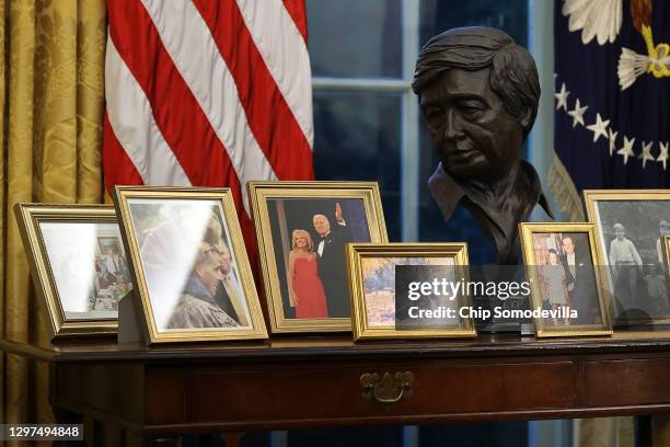 Sculpted bust of Cesar Chavez is seen with a collection of framed photos on a table as U.S. President Joe Biden prepares to sign a series of...