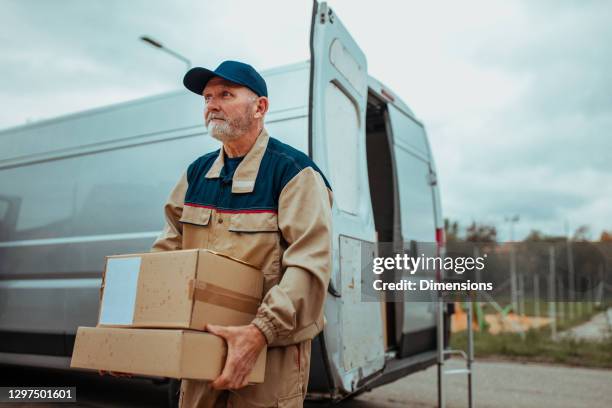 bezorger die kartondoos draagt - postbode stockfoto's en -beelden