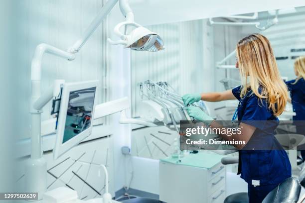 dentist cleaning dental equipment - dental assistant stock pictures, royalty-free photos & images