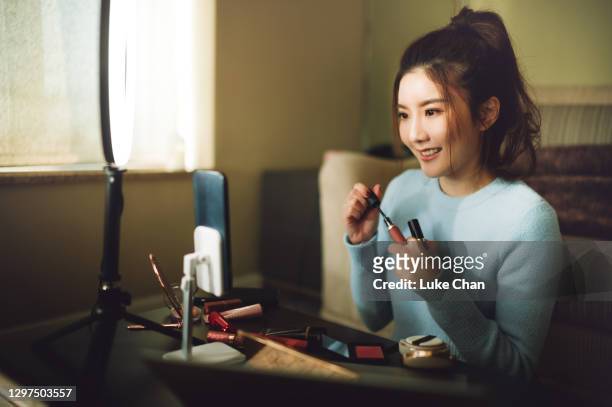 jeune femme asiatique gaie faisant le streaming en direct pour les médias sociaux et internet - applying stock photos et images de collection