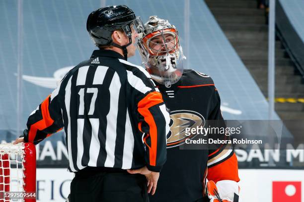 Referee Frederick L'Ecuyer and goaltender John Gibson of the Anaheim Ducks talk while waiting for play to resume during the first period of the game...