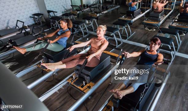 three women in pilates studio - reformer stock pictures, royalty-free photos & images