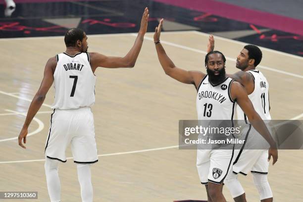 Kevin Durant James Harden and Kyrie Irving of the Brooklyn Nets celebrate during the first quarter against the Cleveland Cavaliers at Rocket Mortgage...