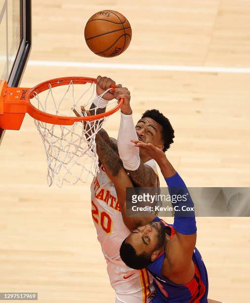 John Collins of the Atlanta Hawks misses this alley-oop dunk as he is defended by Wayne Ellington of the Detroit Pistons during the first half at...