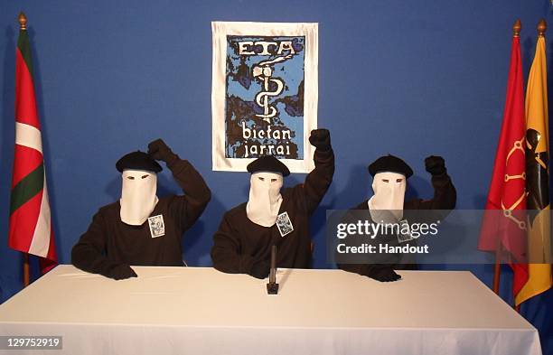 In this undated image provided by Gara, three Eta militants pose in front of the group's symbol of a snake coiled around an axe, in support of a...