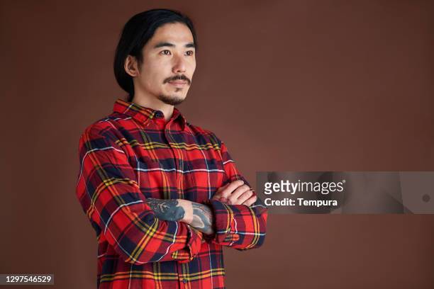 young man portrait wearing a lumberjack shirt. - flannel shirt stock pictures, royalty-free photos & images