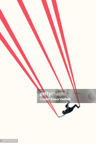 young man hanging from red strings - miteinander verbunden stock-fotos und bilder