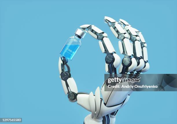 robotic arm holding covid-19 vaccine vial. - robotic arm stock pictures, royalty-free photos & images