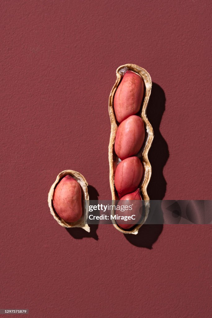 Big and Small Peanuts on Red Background