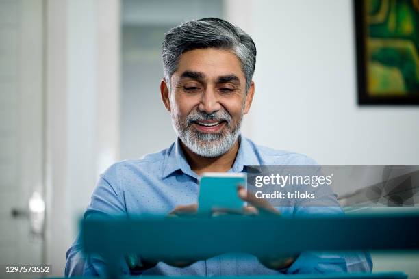 businessman using mobile phone at office - india phone professional stock pictures, royalty-free photos & images