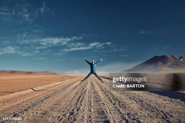 young male tourist star jumps with excitement in atacama desert - san pedro de atacama bildbanksfoton och bilder