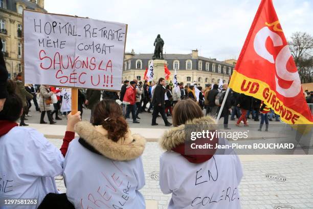 Personnel de santé avec un drapeau CGT et une pancarte "Hôpital - Retraite même combat, Sauvons la Sécu" lors de la manifestation contre le projet de...