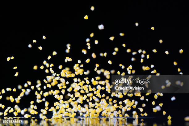 flying corn grain in mid air in black background - corn on black stockfoto's en -beelden