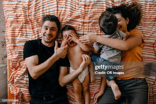 family with two sons lying in bed - moms crying in bed stock pictures, royalty-free photos & images