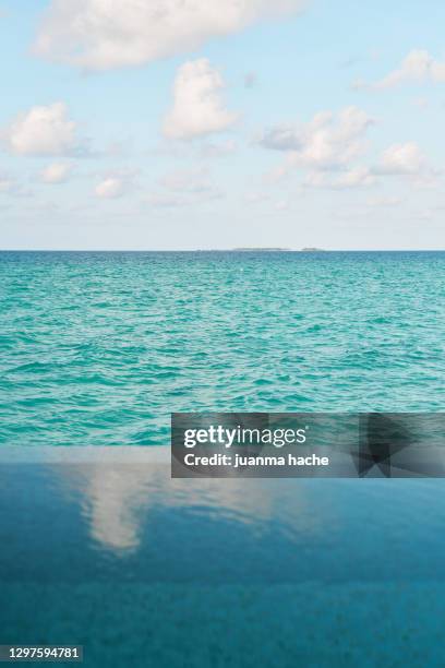 infinity pool against endless blue sea - poolbiljart stockfoto's en -beelden