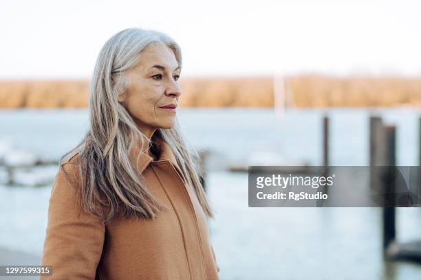 portret van een nadenkende rijpe vrouw die de afstand bekijkt - depressie landelement stockfoto's en -beelden