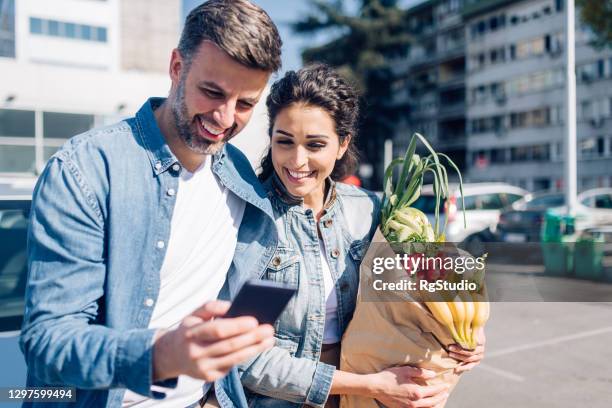 glückliches paar, das vom kauf und online-banking zurückkommt - couple in supermarket stock-fotos und bilder