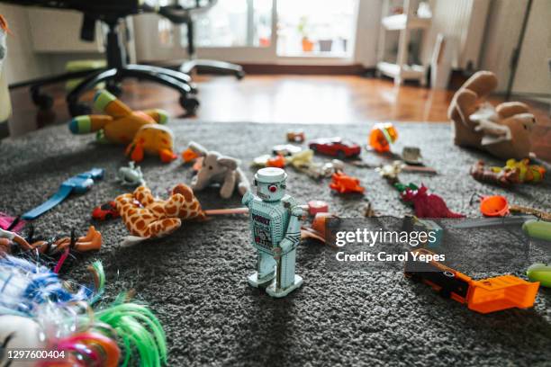 toy robot surrounded by other toys on the carpet in child bedroom - toy stock-fotos und bilder