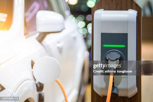 electric car charging - red car wire fotografías e imágenes de stock