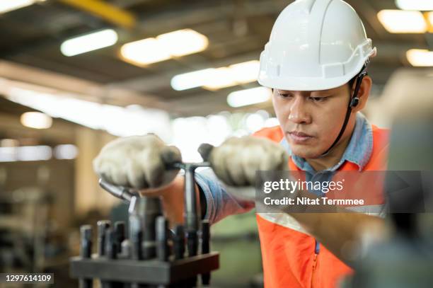shot of industrial male worker adjusting lathe machine by work tool before starting of his work. machinery self check process. - measuring potential business stock pictures, royalty-free photos & images
