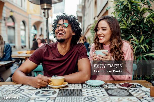 happy diverse couple on a date - outside cafe stock pictures, royalty-free photos & images