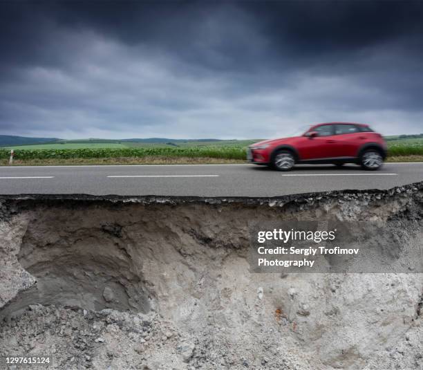 blurred car is driving on broken road with cracked asphalt - earthquake road stock pictures, royalty-free photos & images