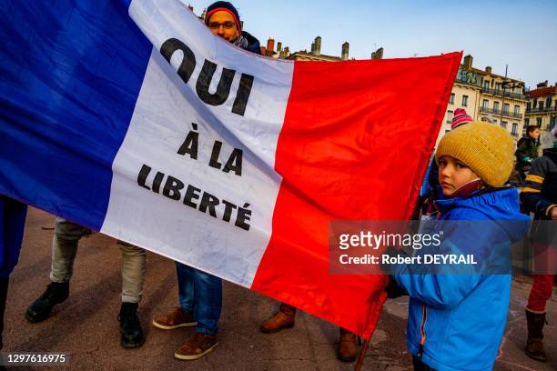 Un enfant port un drapeau français où est écrit "OUI À LA LIBERTÉ" lors de la manifestation qui a rassemblé une centaine de personnes place Bellecour...