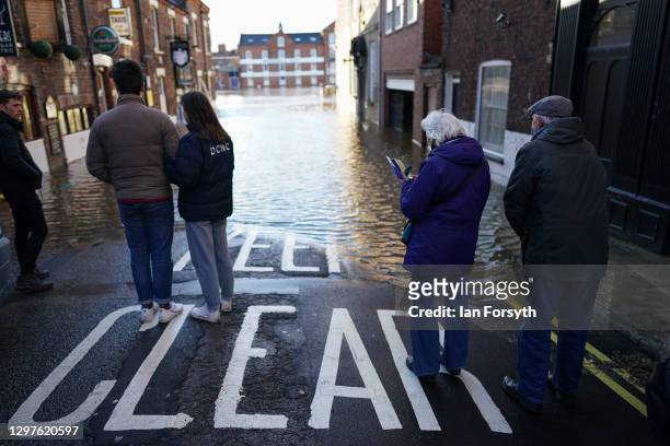 Couples look out over the River Ouse in York as it floods following rain and recent melting snow on January 21, 2021 in York, England. Storm...