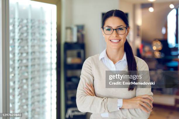 vrouw die oogglazen draagt bij de optische opslag - opticien stockfoto's en -beelden