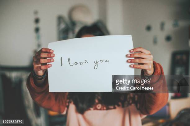 female holding a paper wiht i love you text - love letter stock-fotos und bilder