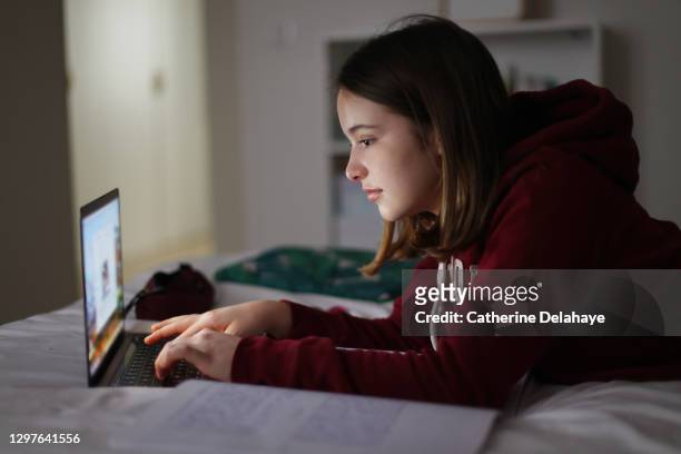 a 15 years old girl attending online school classes from home - 15 years stockfoto's en -beelden