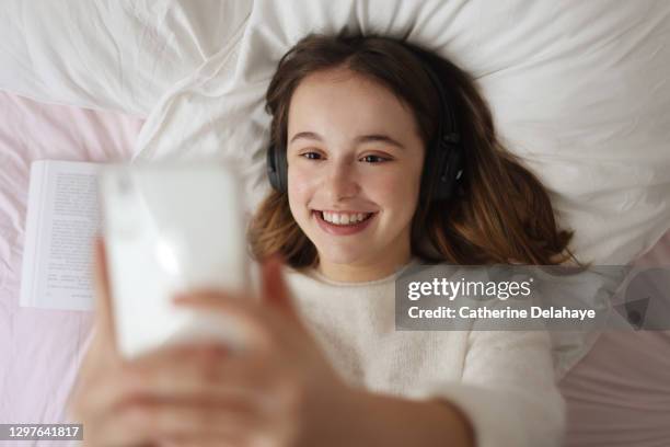 a 15 years old girl looking at her phone at home - 14 15 years fotografías e imágenes de stock