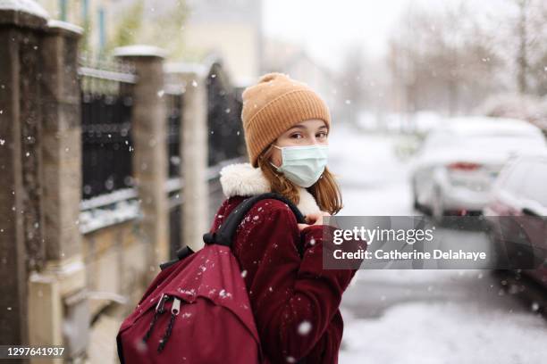 a 15 years old girl wearing a mask in a snowy street - france coronavirus stock pictures, royalty-free photos & images