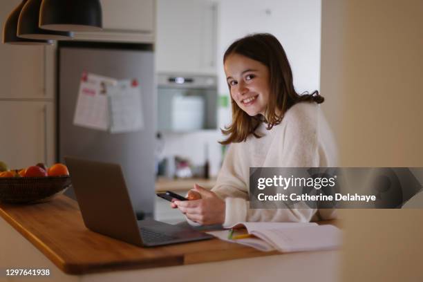 a 15 years old girl attending online school classes from home - 14 15 years stockfoto's en -beelden