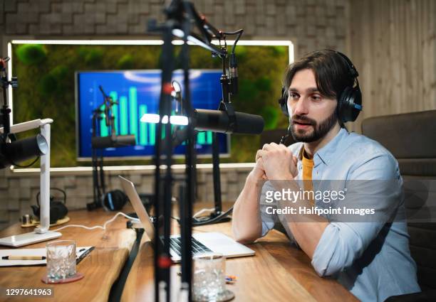 young man makes a podcast audio recording in a studio. - microphone desk fotografías e imágenes de stock
