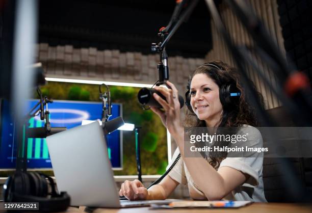 young woman makes a podcast audio recording in a studio. - content stock-fotos und bilder