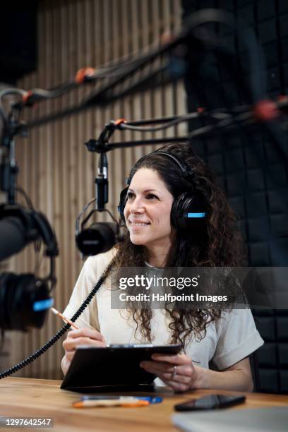 young woman makes a podcast audio recording in a studio. - radio broadcasting stock pictures, royalty-free photos & images