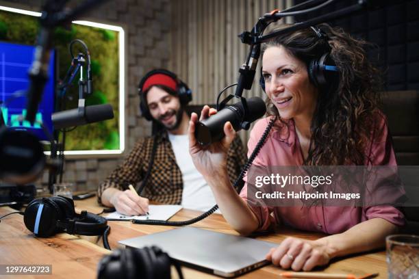 young woman and man makes a podcast audio recording in a studio. - radiogerät stock-fotos und bilder