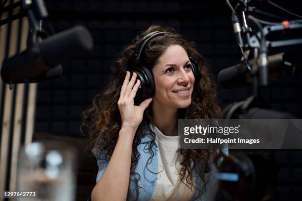 young woman makes a podcast audio recording in a studio. - live broadcast stock-fotos und bilder