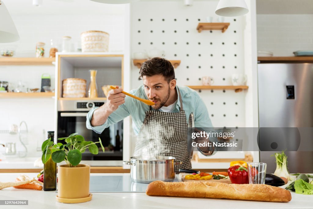 Mann in der Küche Kochprobe