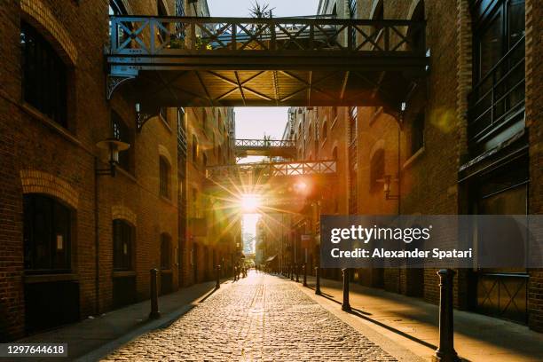 sun shining through shad thames street during sunset, london, uk - south bank - fotografias e filmes do acervo