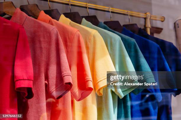 multi-colored polo shirts hanging on a rack in a store - tシャツ　無人 ストックフォトと画像